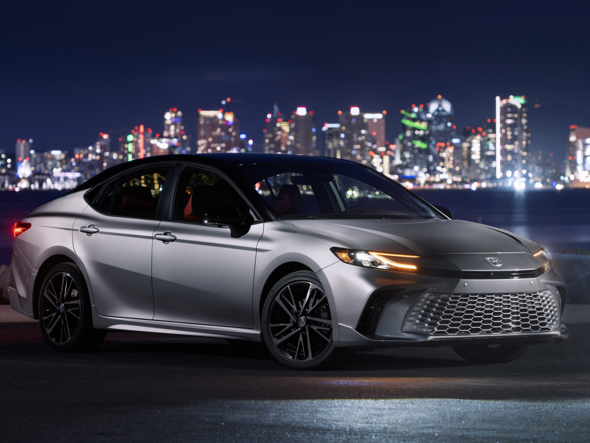 Новый автомобиль Toyota Camry XSE HEV AWD 2025 года на фоне города