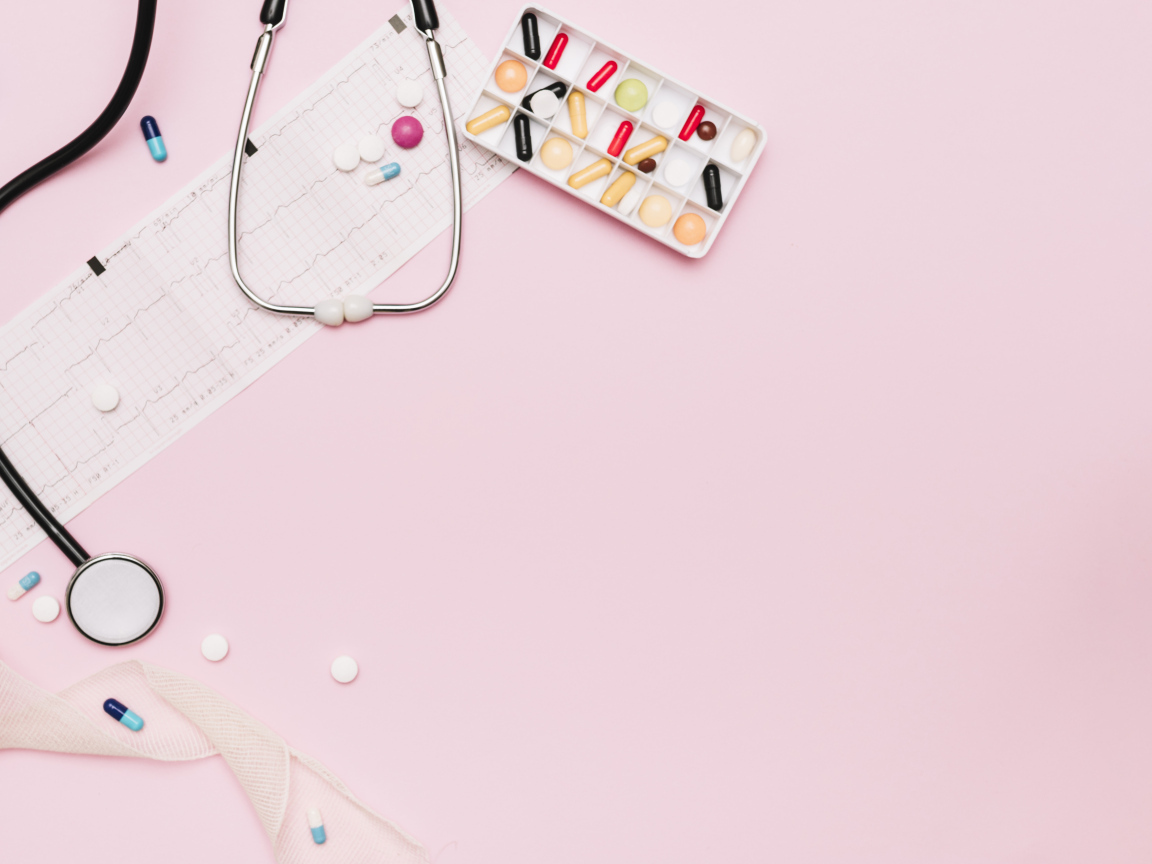 Стетоскоп и лекарства на кардиограмме на розовом фоне