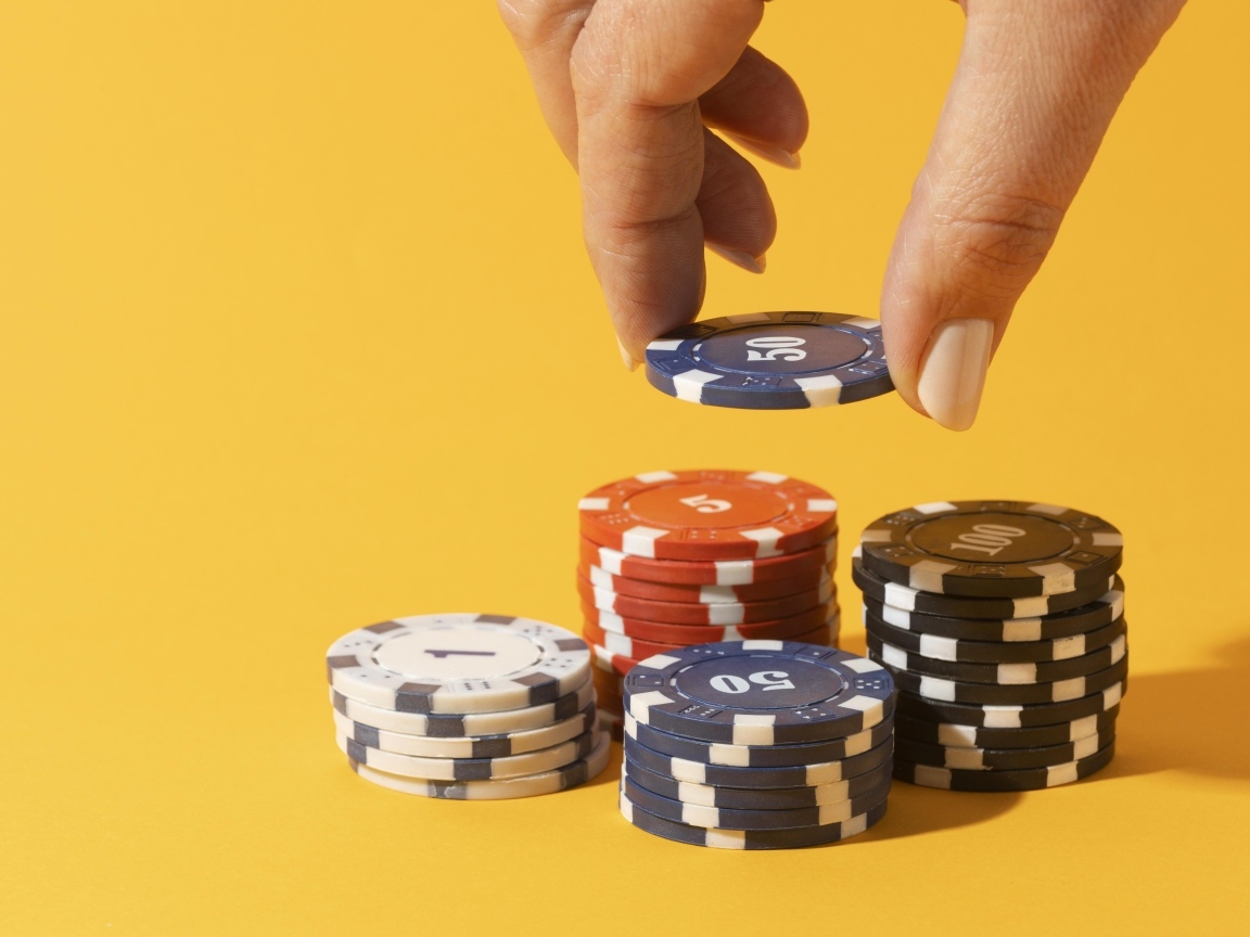 Фишки для казино с рукой на желтом фоне