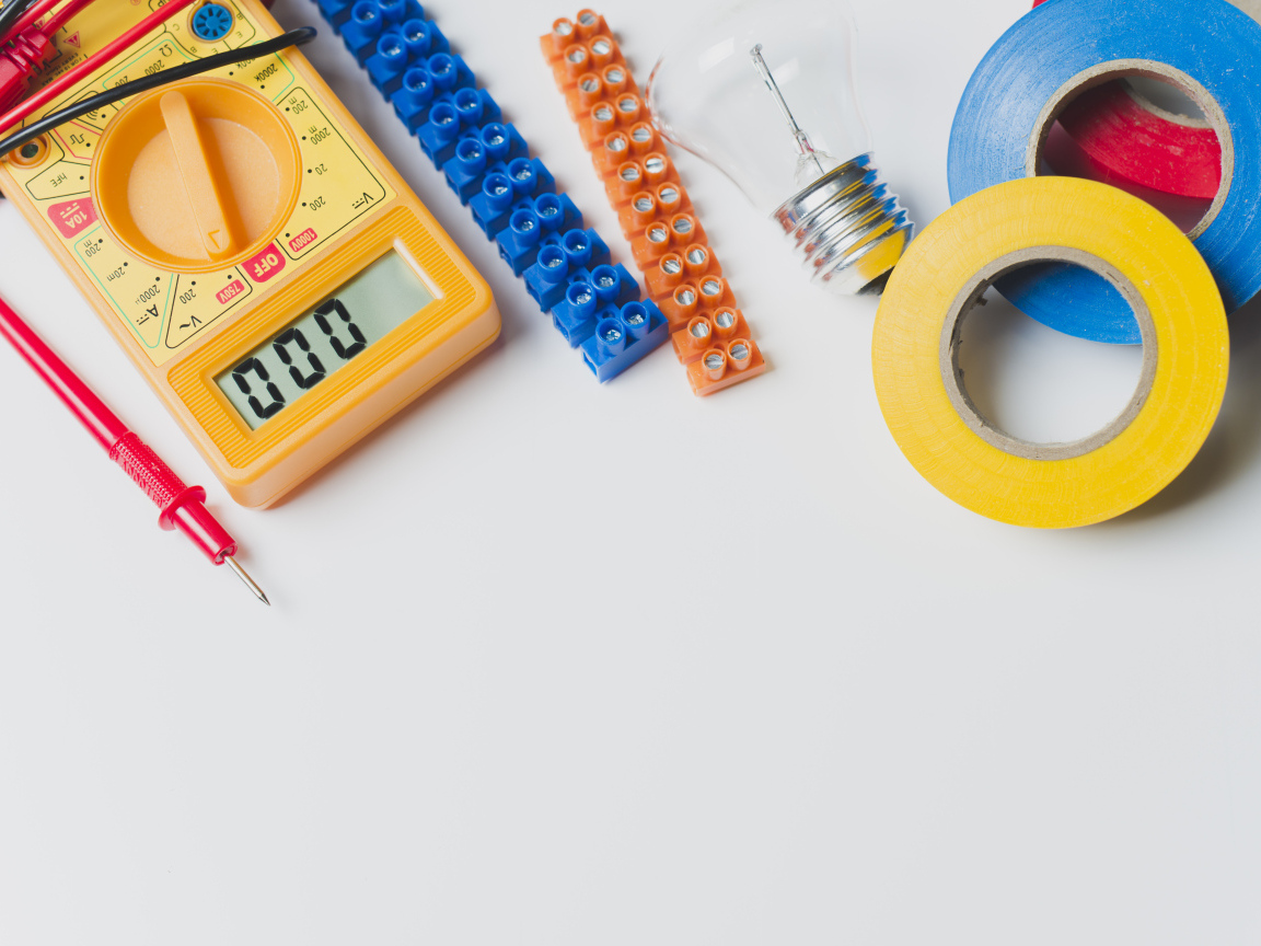 Электрическические приборы, мультиметр, изолента на сером фоне