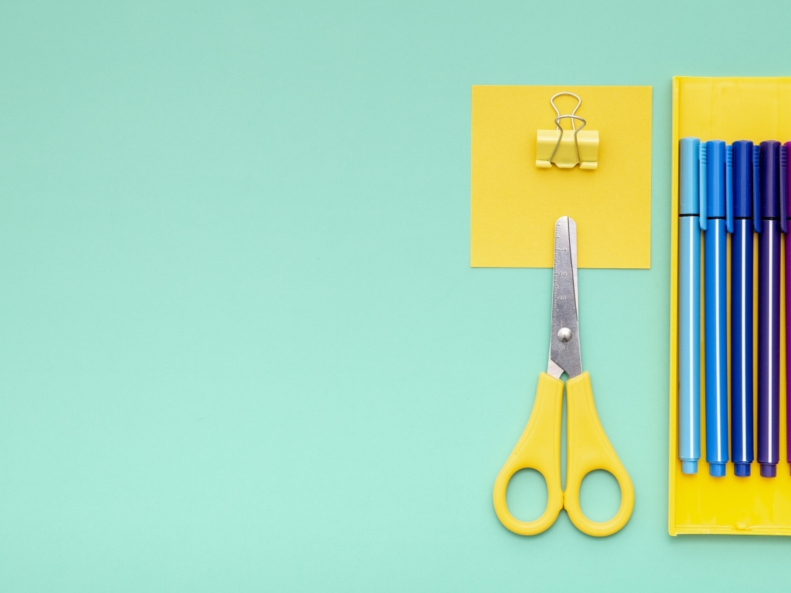 Фломастеры, ножницы и карандаш на голубом фоне