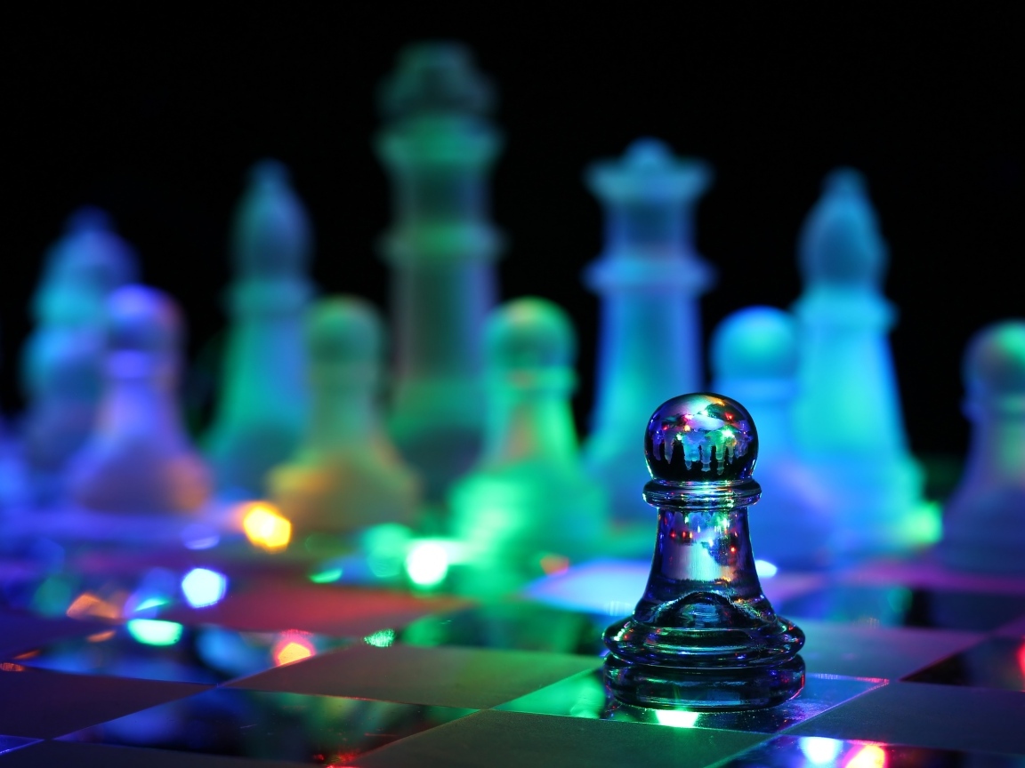 Стеклянные шахматы с гирляндой лежат на доске