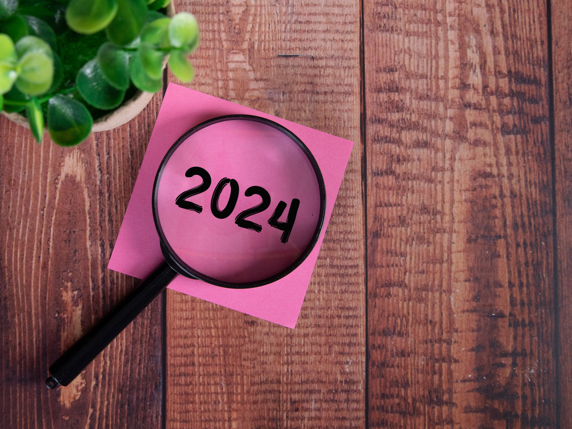 Увеличительное стекло с листом бумаги и цветком на столе