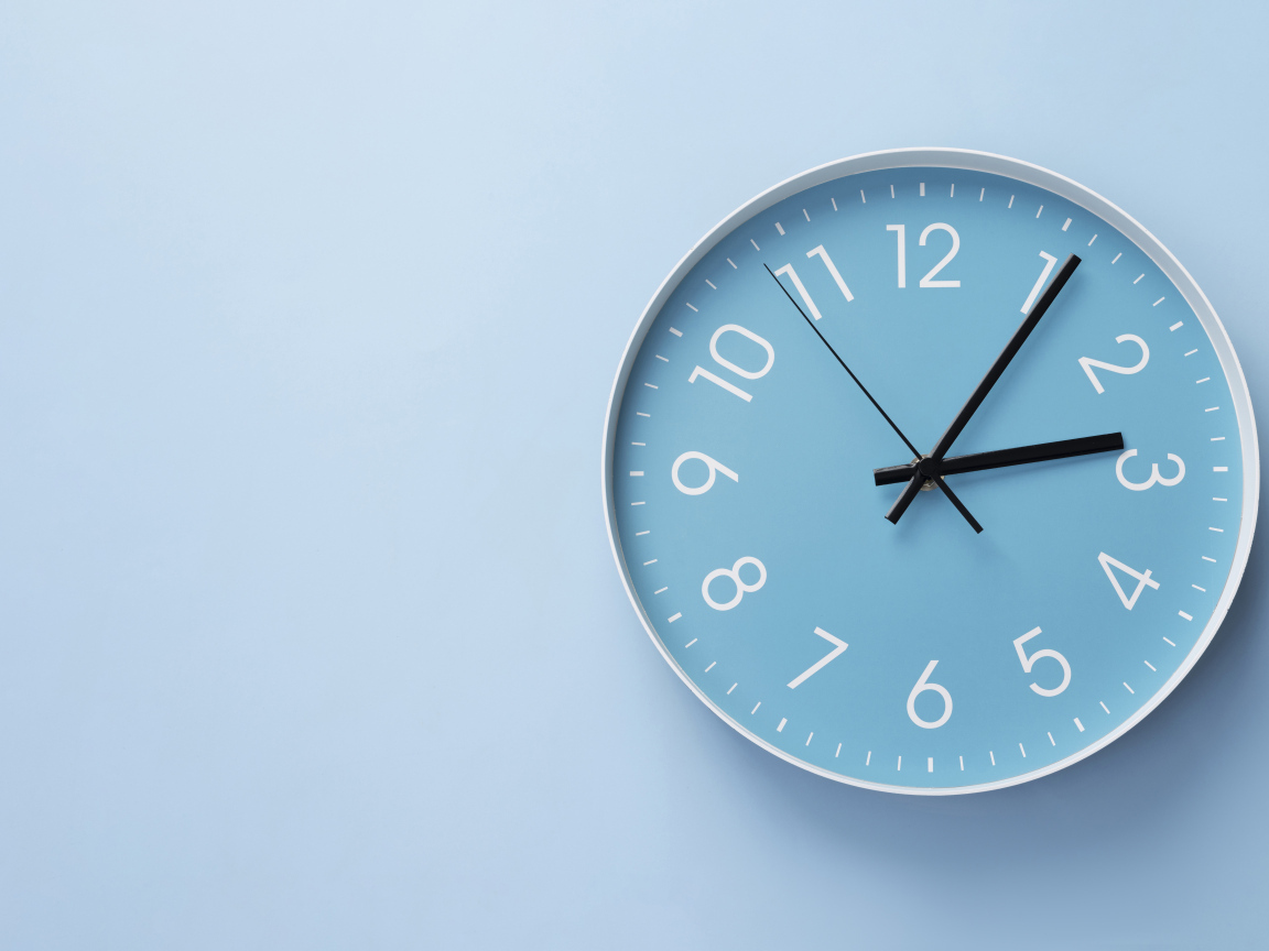 Круглые часы на голубом фоне крупным планом