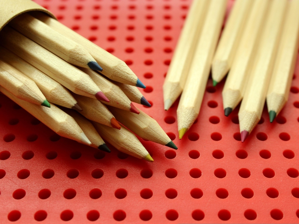 Заточенные карандаши на красном фоне