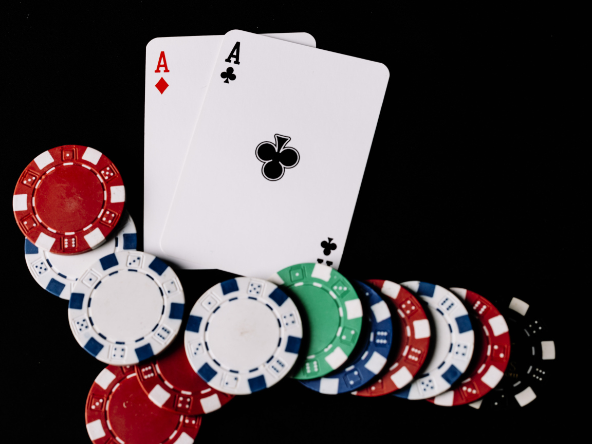 Два туза и фишки для покера  на черном фоне