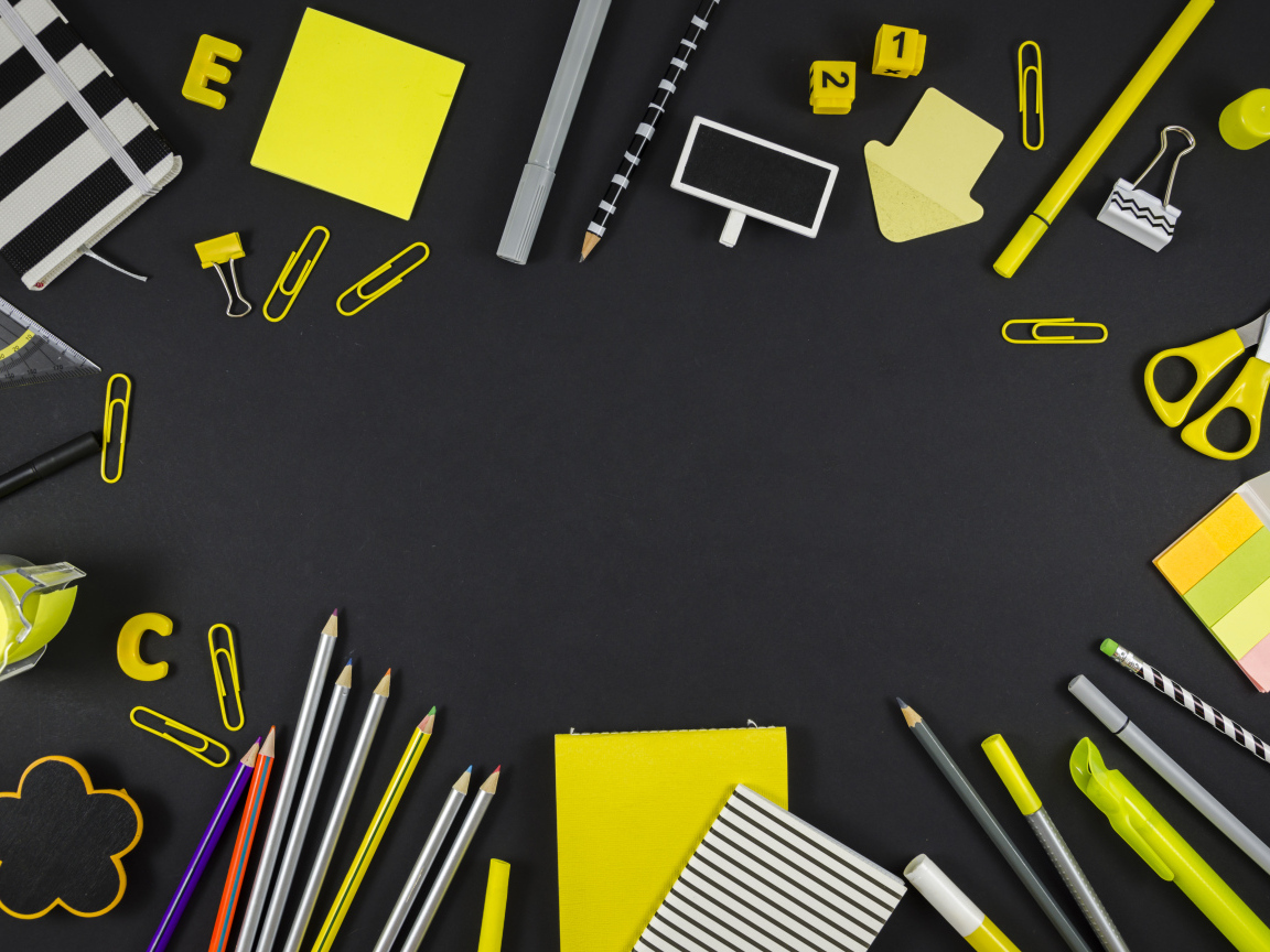 Желтые разные канцелярские предметы на черной поверхности 