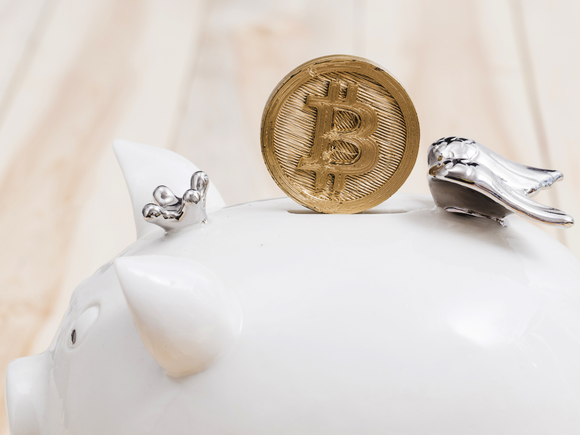 Золотая монета биткоин с копилкой
