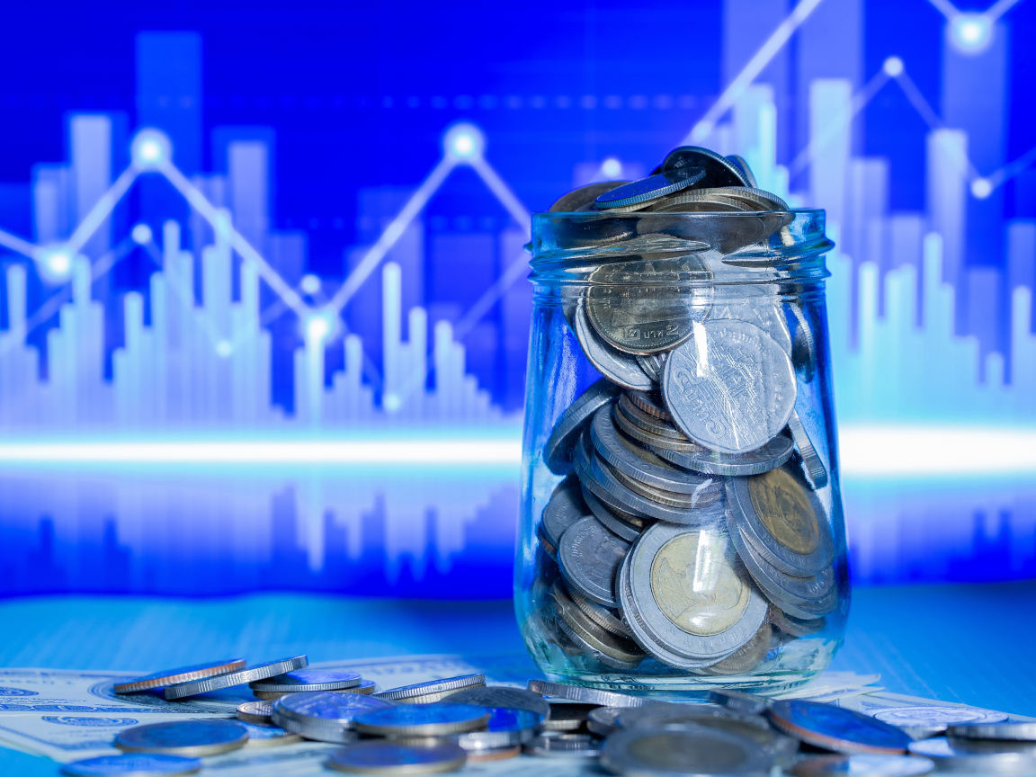 Банка с монетами на фоне таблицы