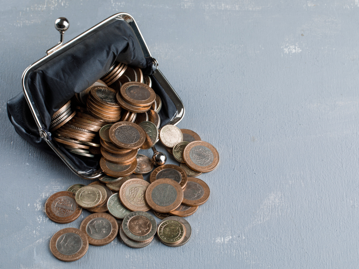 Кошелек с монетами на сером столе