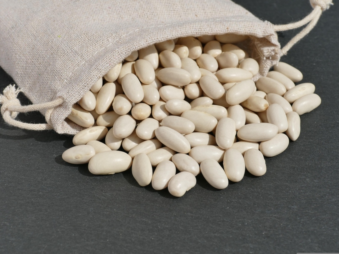 Фасоль в мешочке на сером столе