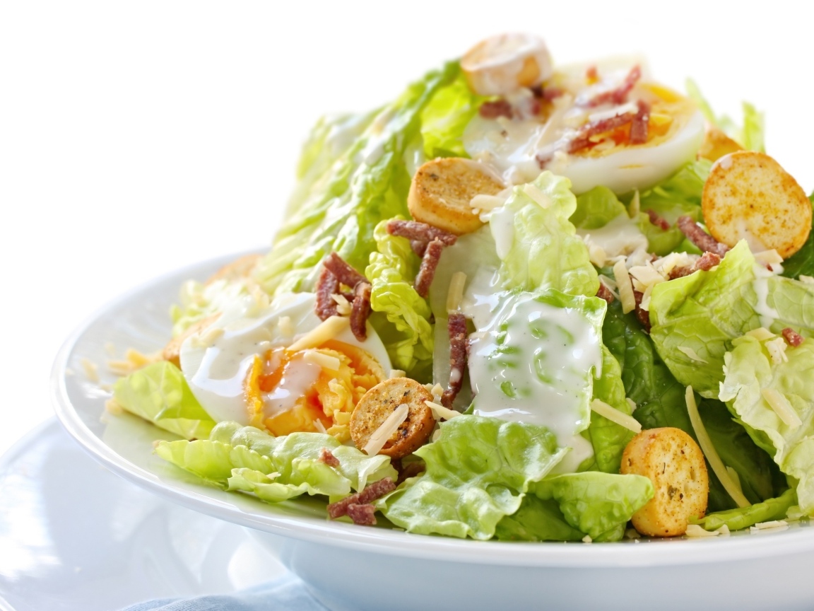 Салат Цезарь на большой белой тарелке