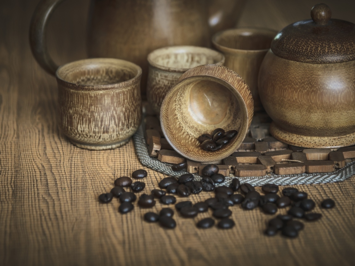 Кофейные зерна с посудой на столе