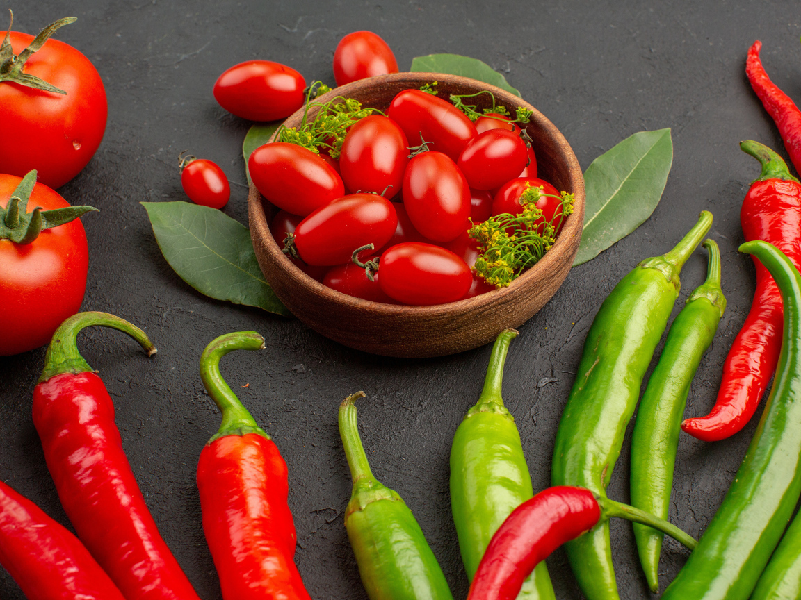 Свежие помидоры на столе с острым перцем