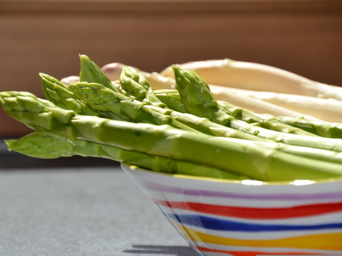 Зеленая спаржа в тарелке на столе