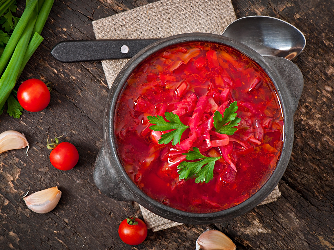 Большая тарелка красного борща на столе