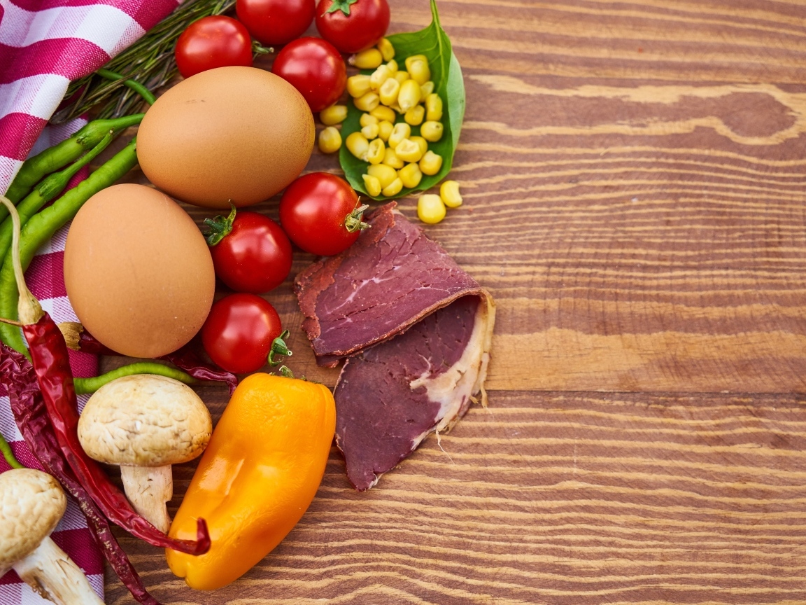 Продукты на деревянном столе с полотенцем