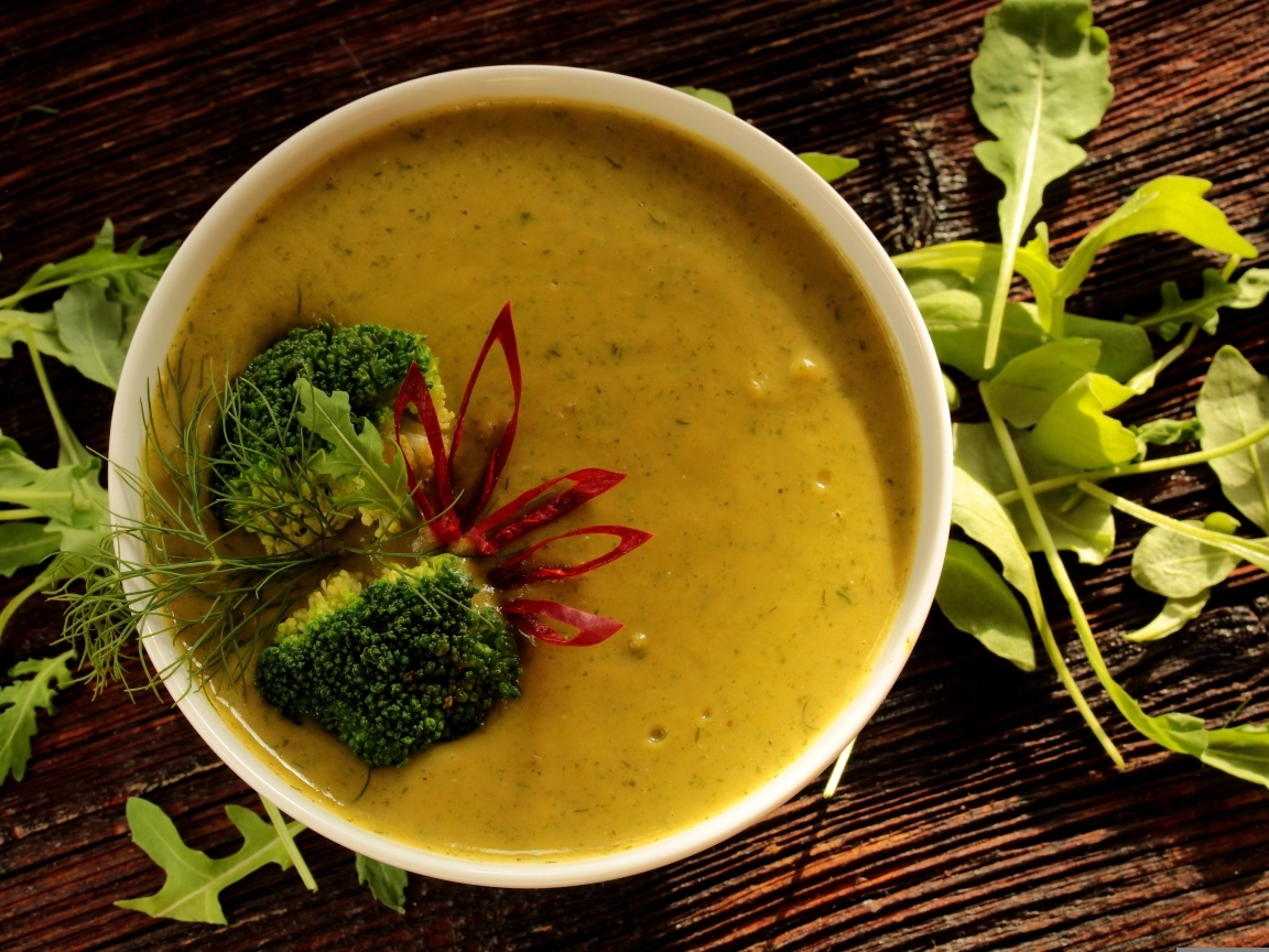 Суп пюре в тарелке с брокколи и зеленью