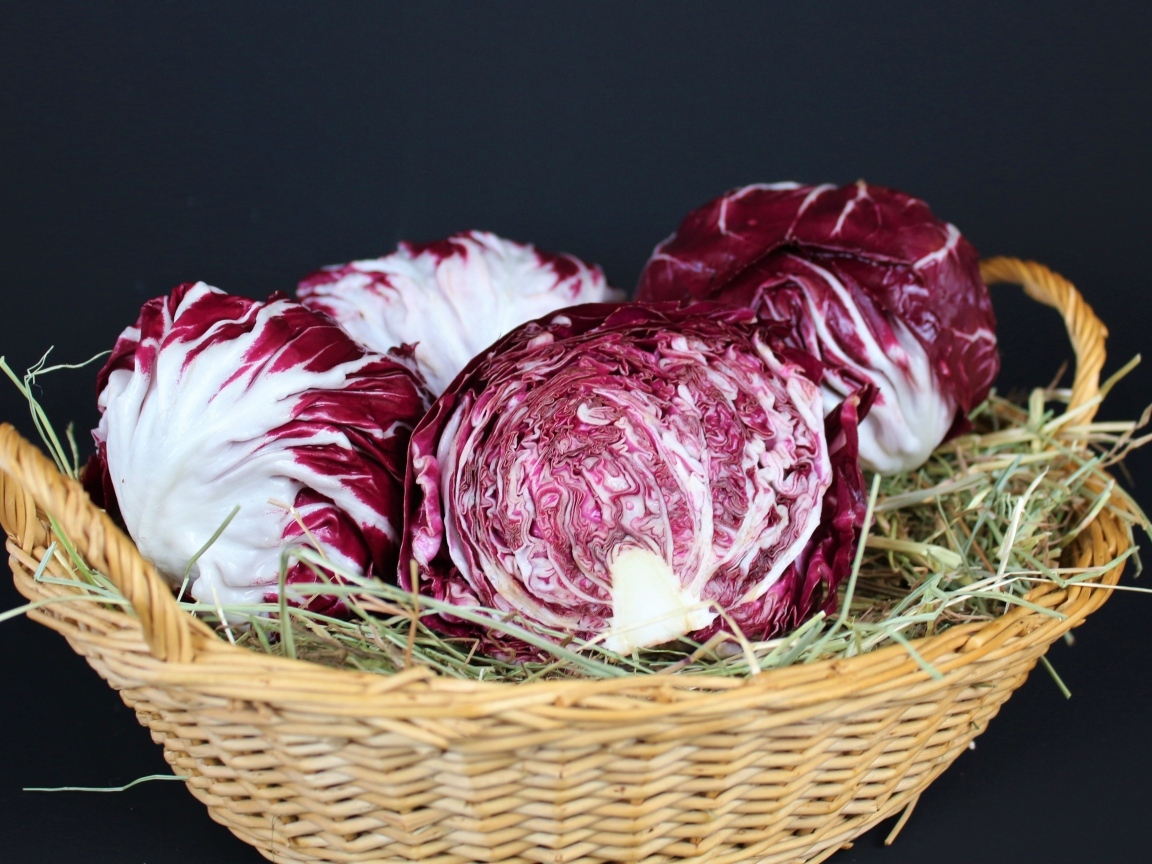 Красная капуста в корзине на черном фоне
