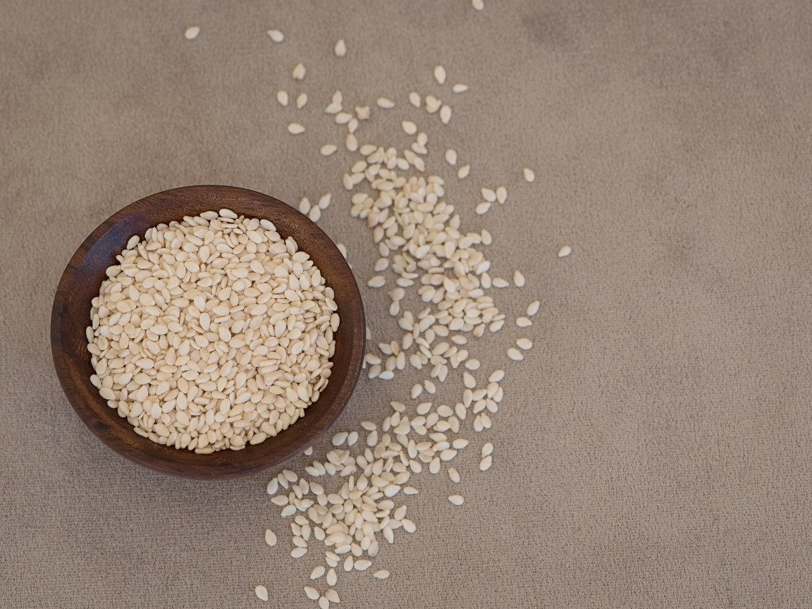 Зерна кунжута в деревянной миске на столе