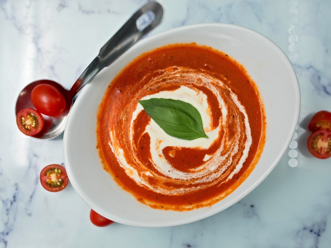 Томатный суп со сметаной в белой тарелке