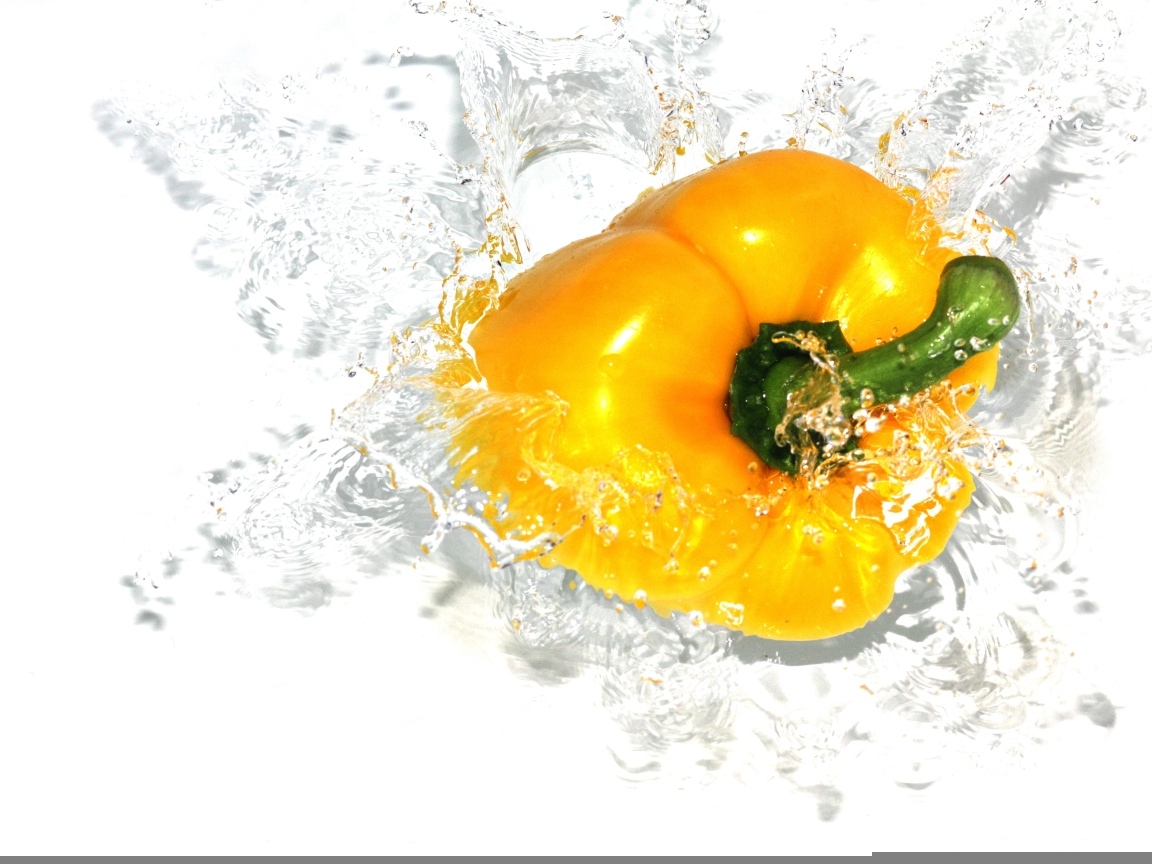 Желтый сладкий перец в воде на белом фоне