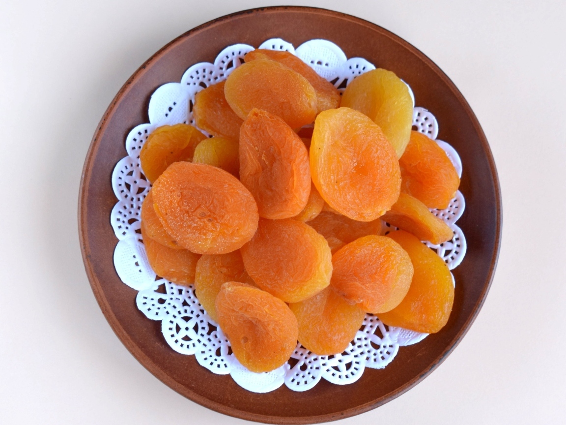 Курага с тарелке на сером фоне