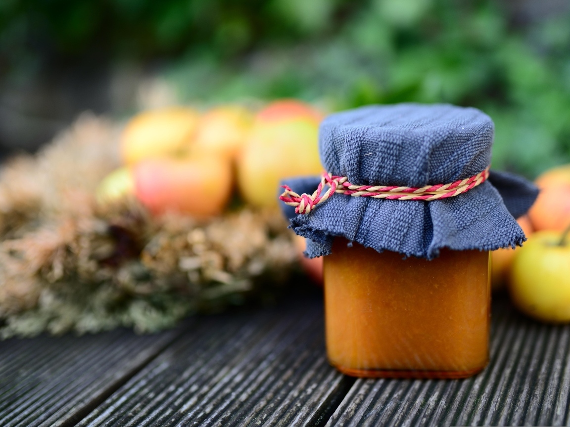 Банка яблочного джема на столе крупным планом