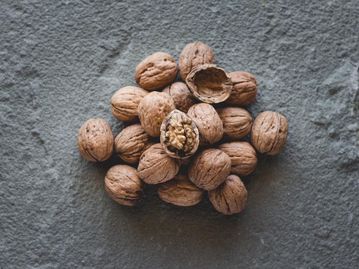 Куча грецких орехов на сером столе