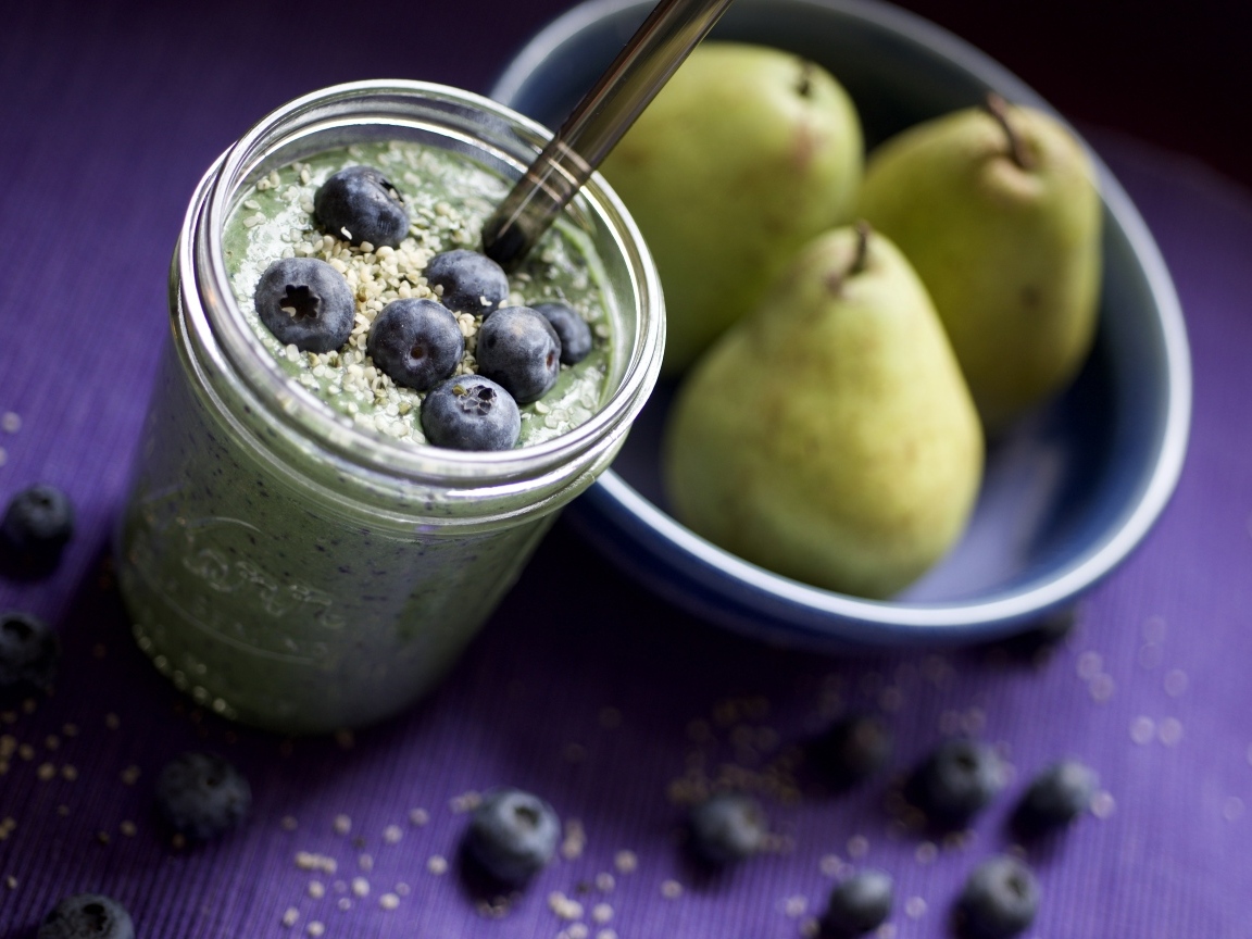 Смузи с ягодами черники на столе с грушами