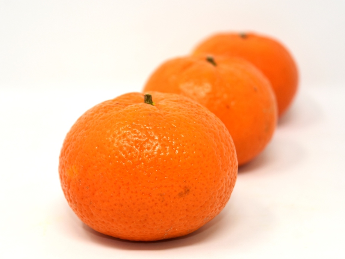 Три больших спелых мандарина на столе