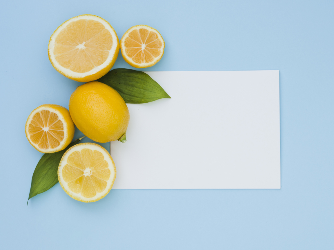 Белый лист бумаги с лимонами и апельсинами на голубом фоне