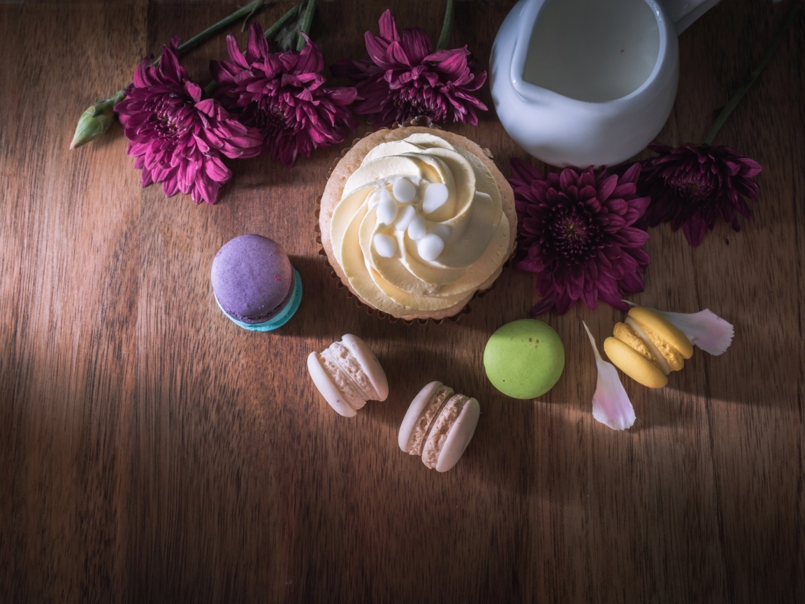 Аппетитные сладкие пирожные с цветами хризантемы на столе