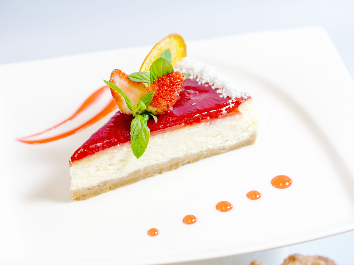 Чизкейк с клубничным джемом и ягодами на белой тарелке