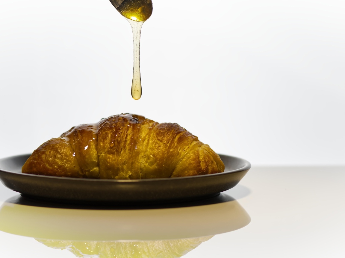 Свежий круассан с медом на завтрак