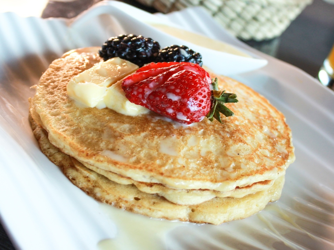 Блины с ягодами на тарелке крупным планом