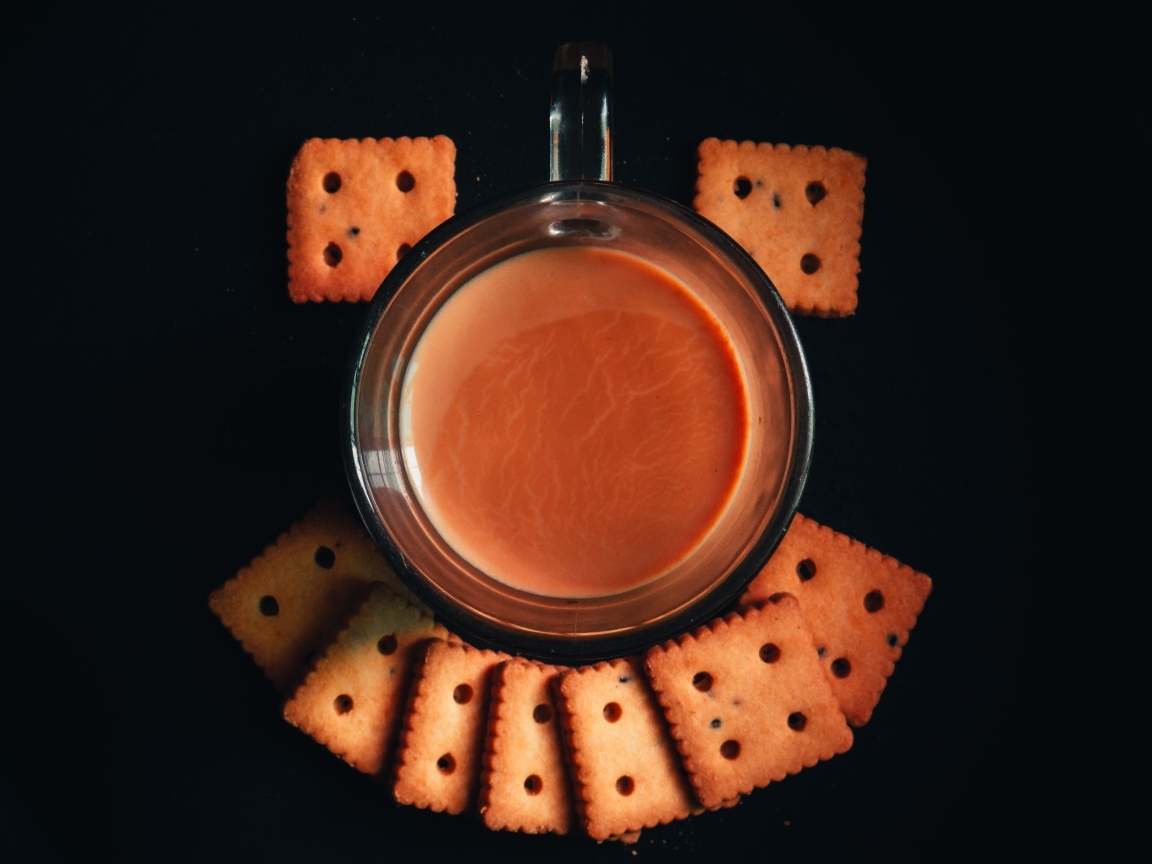 Чашка какао с печеньем на черном фоне