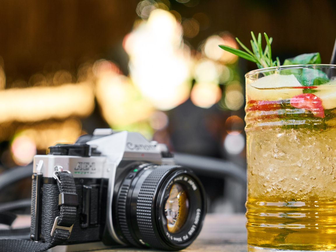 Ретро фотоаппарат с коктейлем на столе