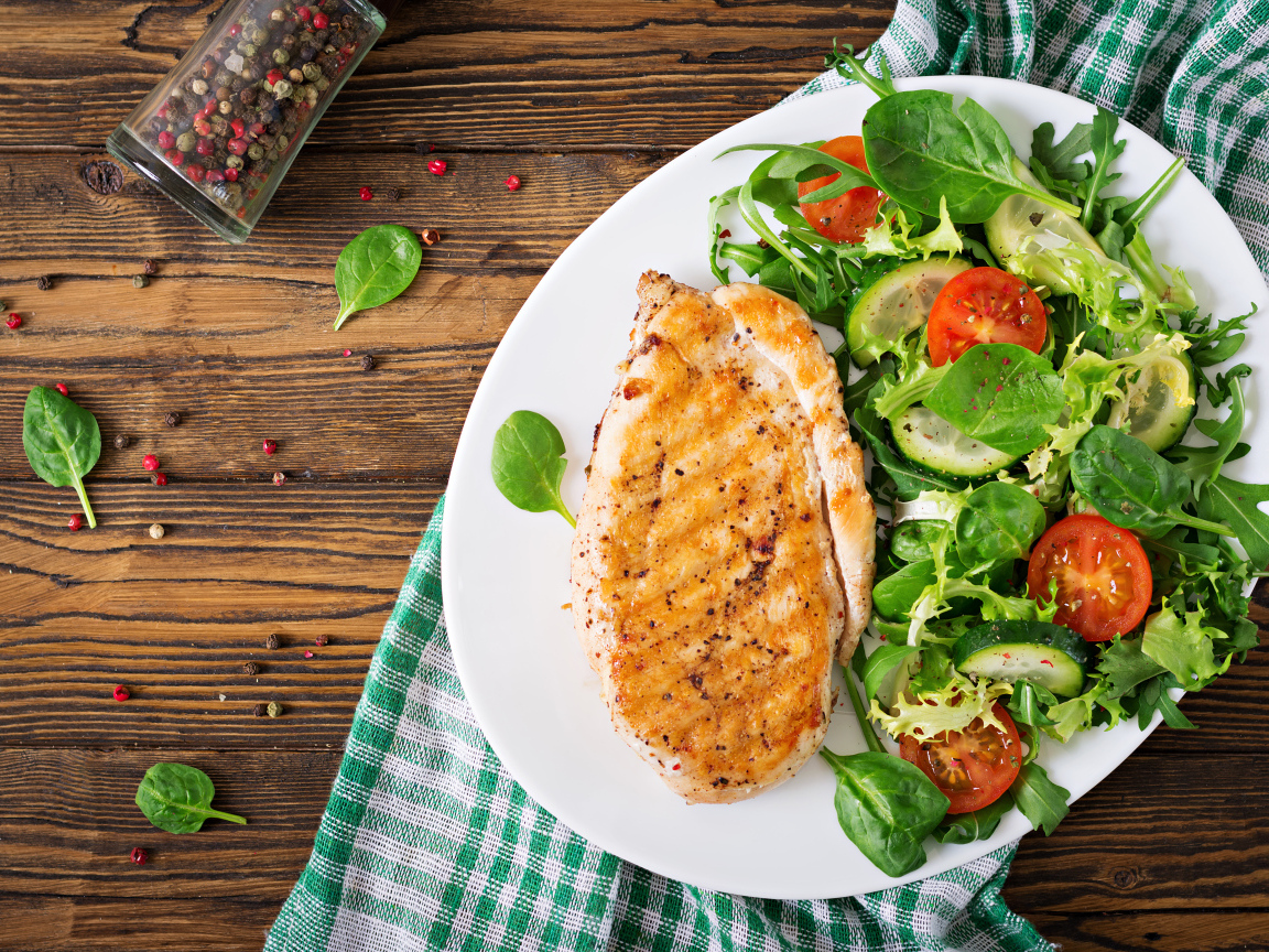 Жареная куриная грудка на тарелке с салатом