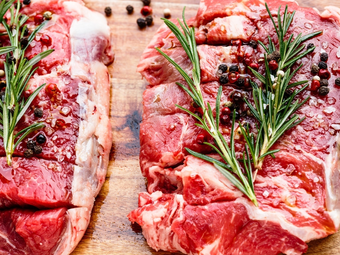 Кусок свежего мяса с перцем и розмарином