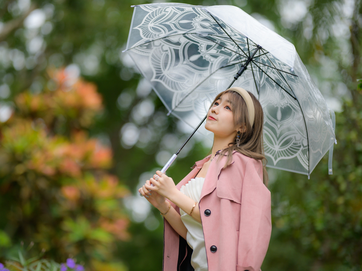 Девушка азиатка в пальто под прозрачным зонтом