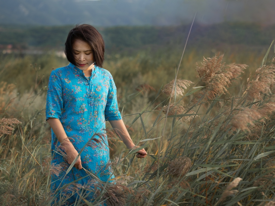 Девушка азиатка в платье на поле с колосьями