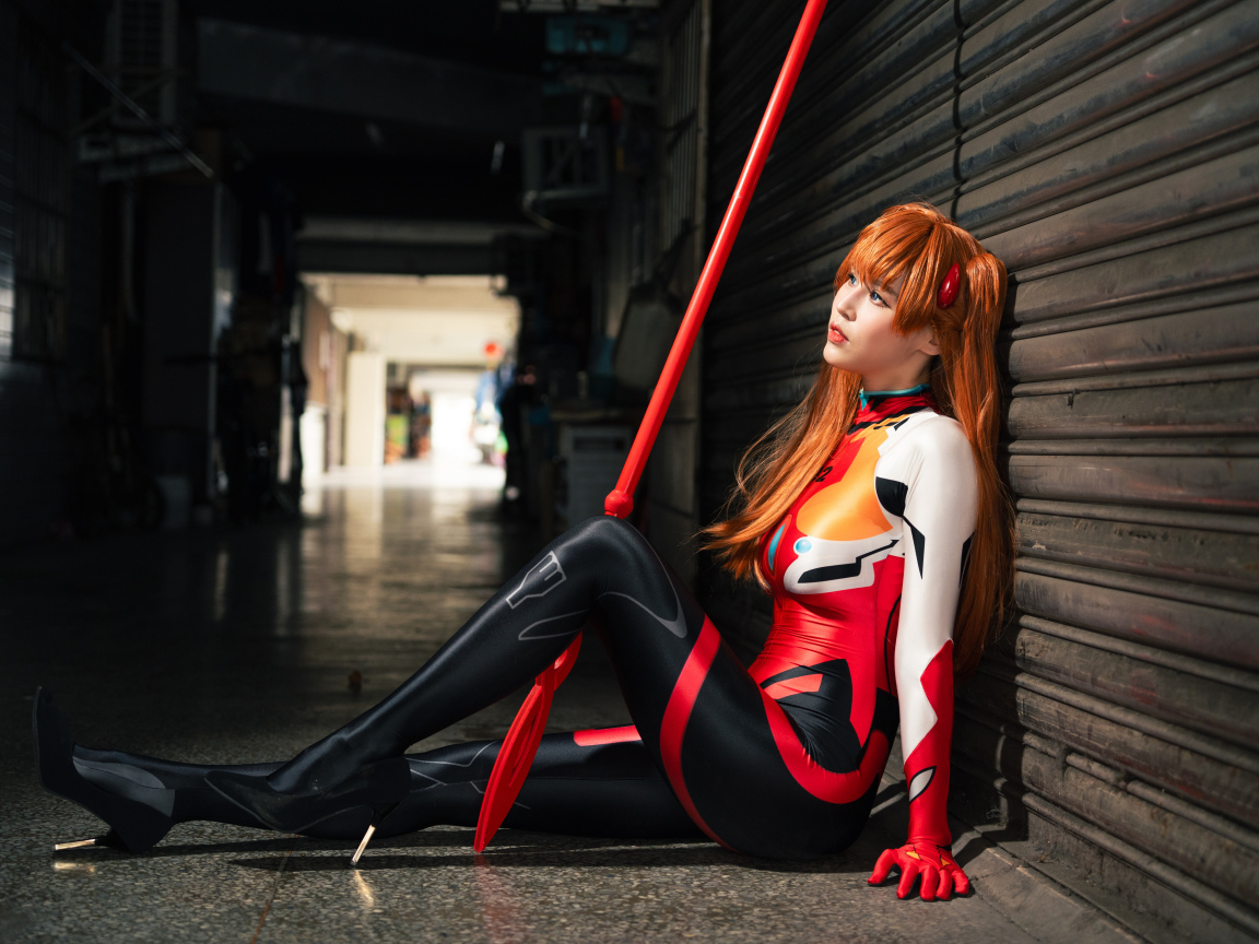 Девушка азиатка в костюме сидит у стены