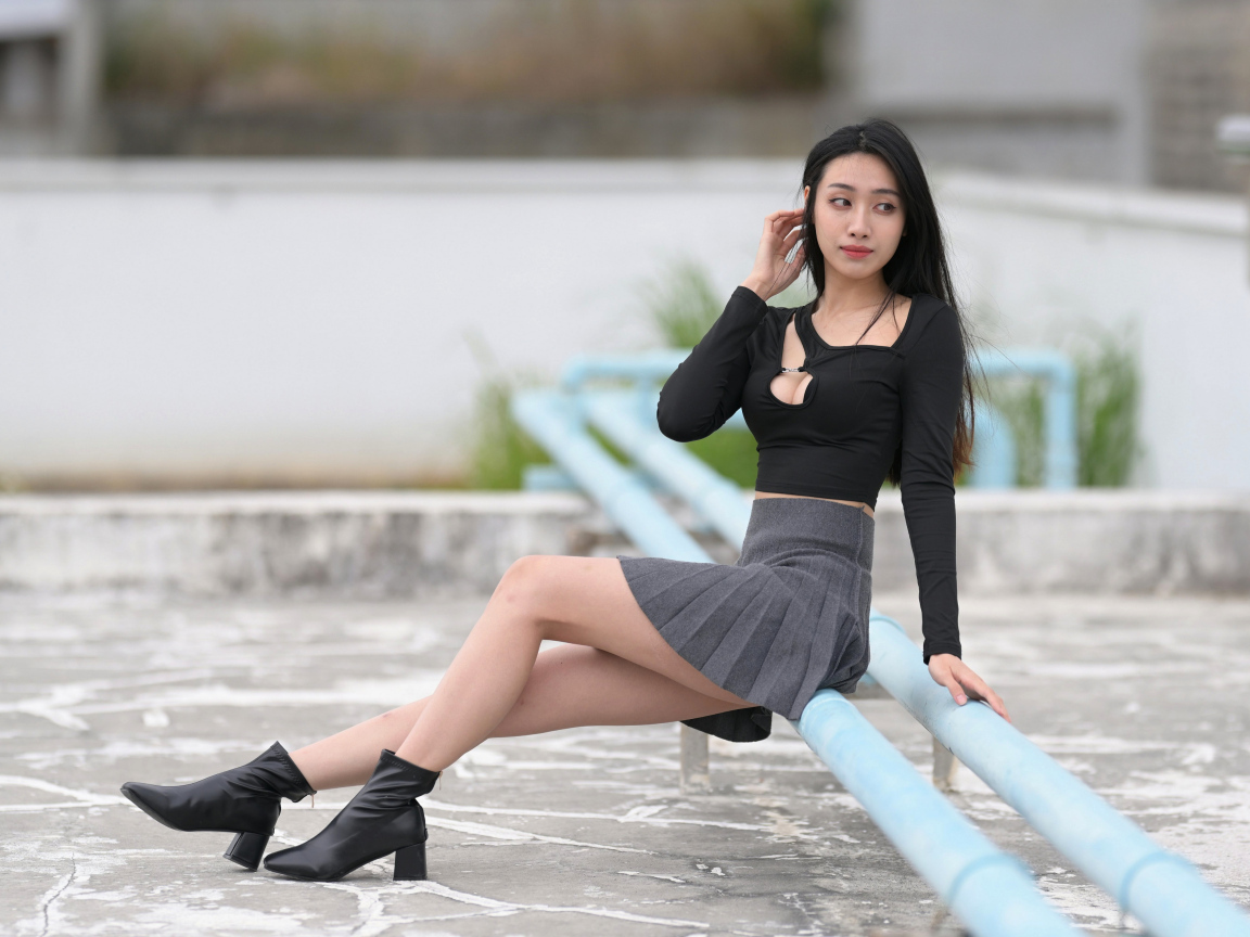 Азиатка в короткой юбке сидит на трубе