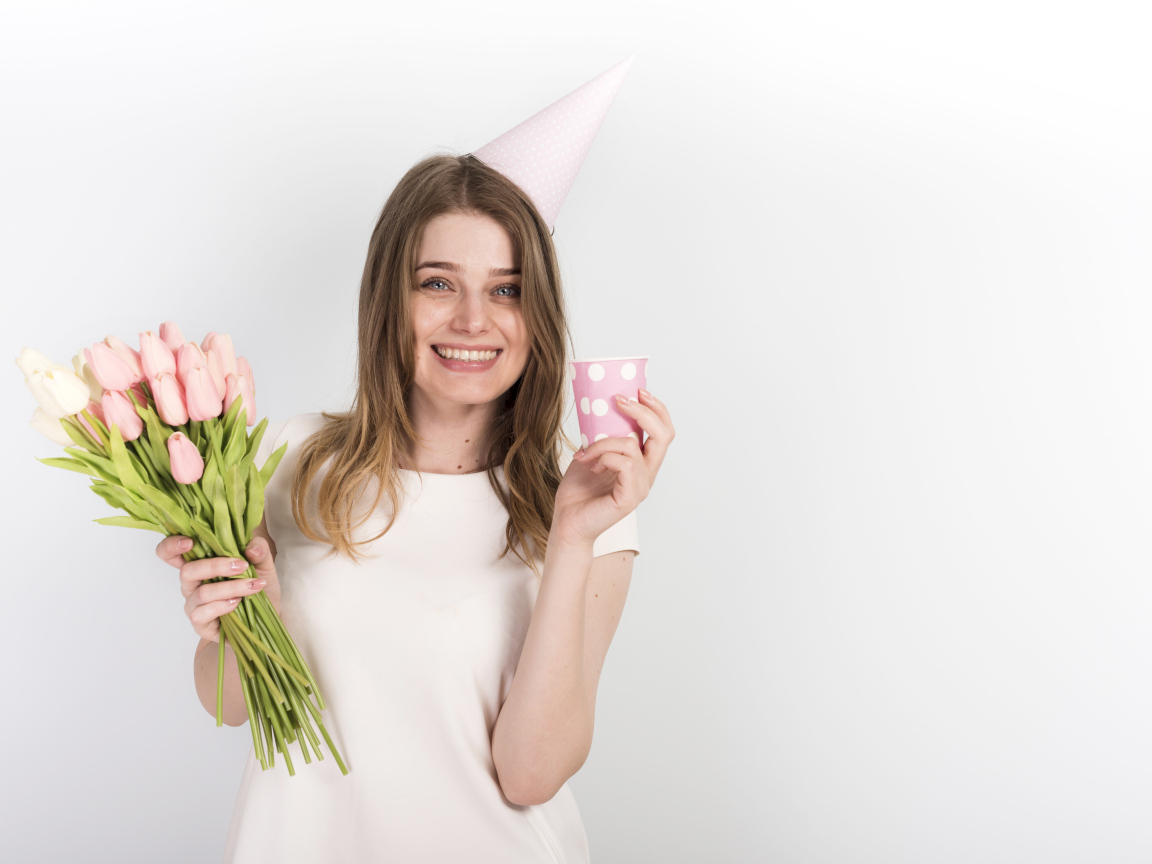 Счастливая девушка с букетом тюльпанов и подарком на день рождения