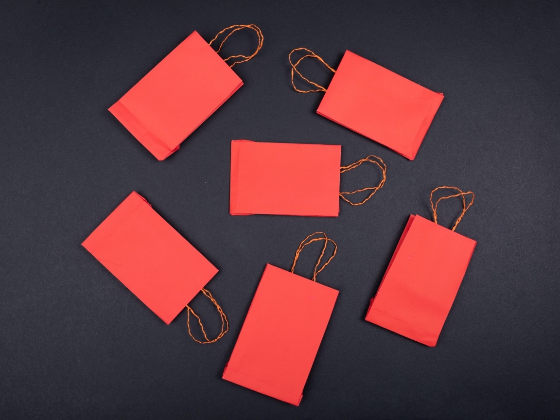 Красные пакетики для подарков на черном столе