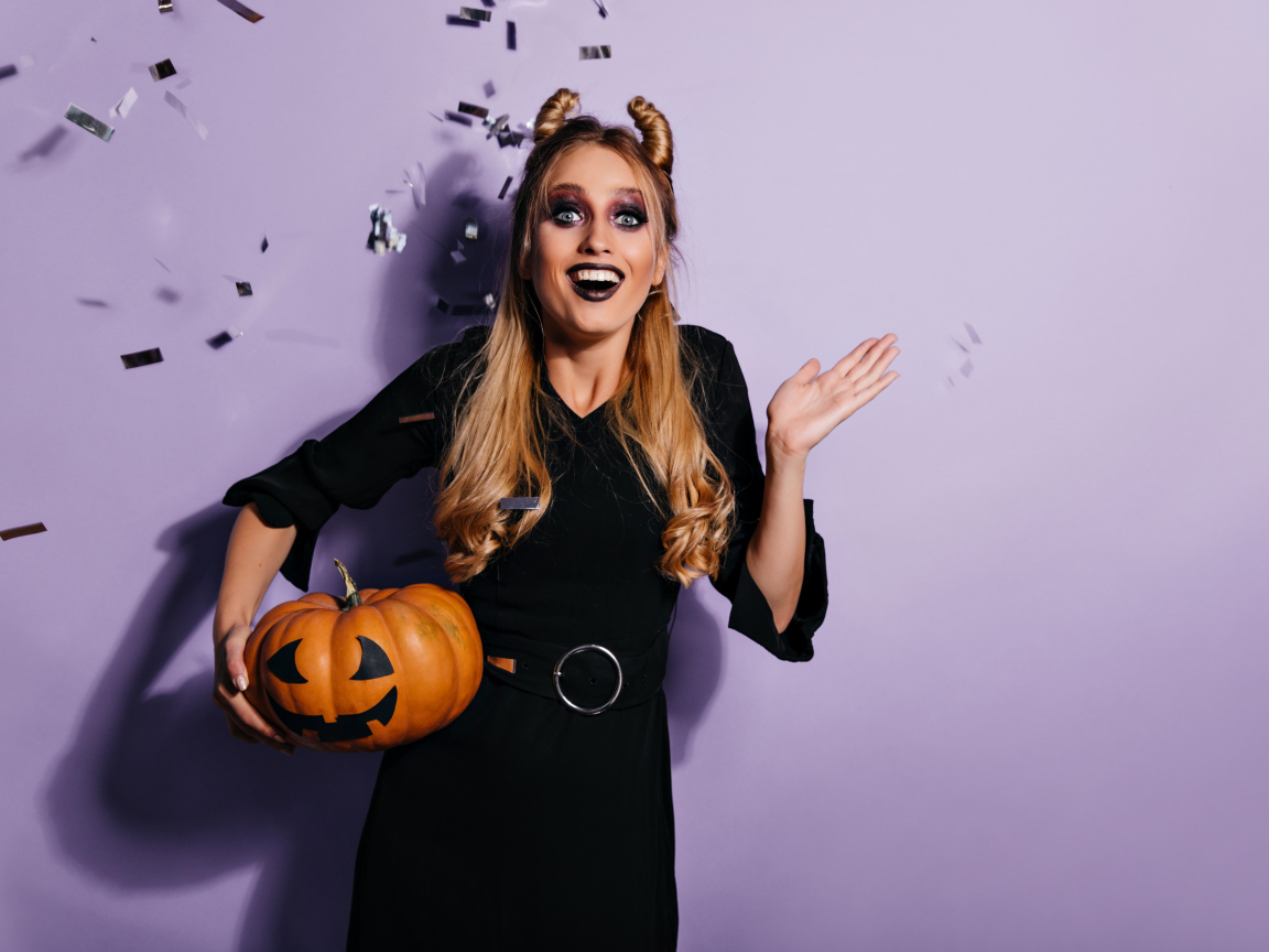 Девушка в черном костюме с тыквой на праздник Хэллоуин