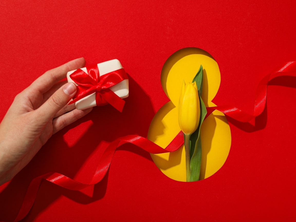 Красный фон с подарком, желтым тюльпаном и цифрой на 8 марта
