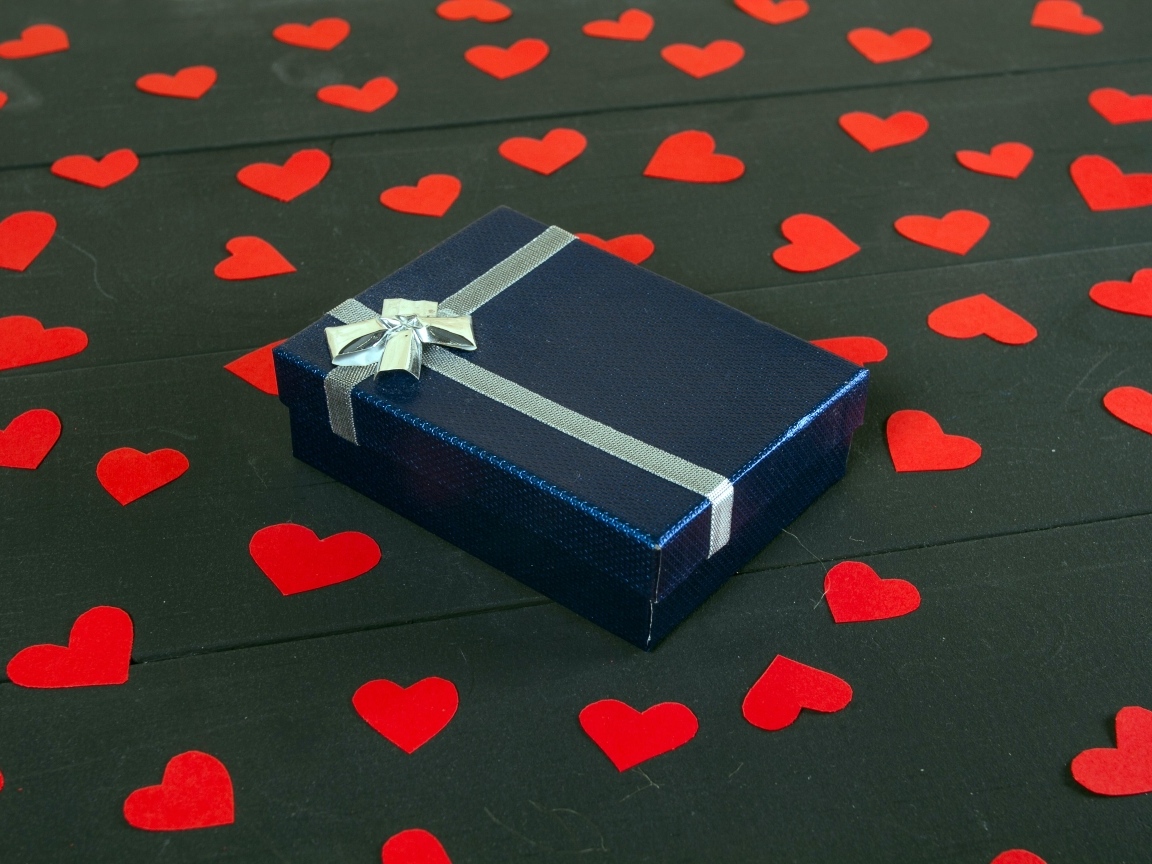 Черная коробка с красными сердечками на столе
