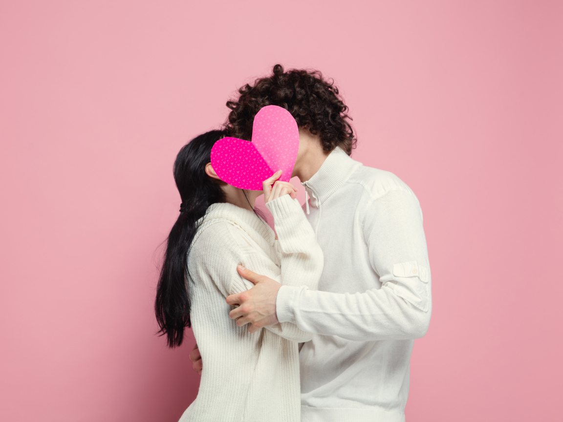 Влюбленная пара закрылась сердечком на розовом фоне